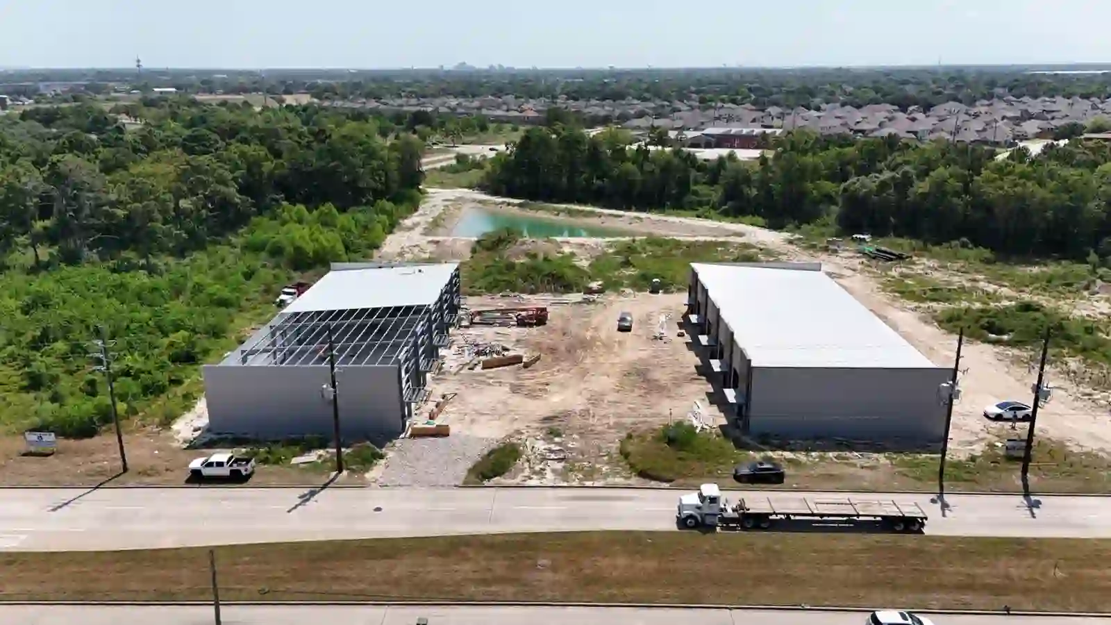 Bammel Business Park Phase 1 aerial drone photo, 18 August 2026 (Day 170): right building fully clad with finished roof, left building steel-framed with wall panels being installed, both flex warehouse buildings on 5.33 acres at 12902 Bammel N Houston Rd, Houston TX 77066